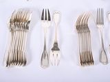 several forks and spoons laid out on a white surface