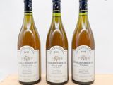 trois bouteilles de vin posées sur un plateau en bois