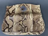 a close up of a snake skin purse on a table
