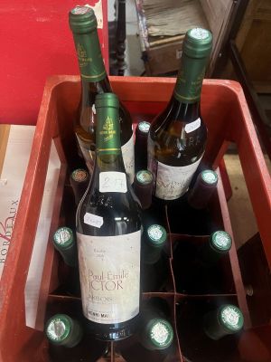 Plusieurs bouteilles de vin se trouvent dans une boîte rouge posée sur une table
