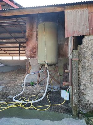 un réservoir d'eau et un tuyau devant un immeuble
