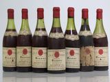 six bottles of wine are lined up in a row on a table