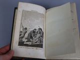 someone is holding an open book with a drawing of a man on it