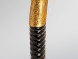 a close up of a black and gold pen with a gold handle