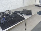 two laptops sitting on a table with wires attached to them