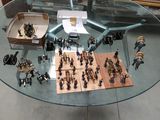 une table en verre sur laquelle sont disposés de nombreux petits soldats