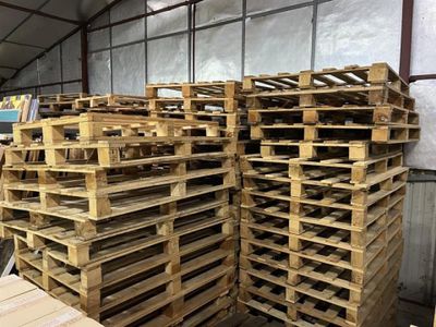 de nombreuses palettes en bois empilées les unes sur les autres dans un entrepôt