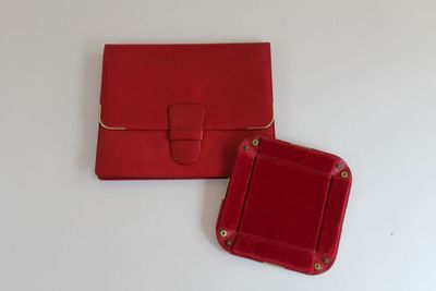 pair of red leather purses on a white surface