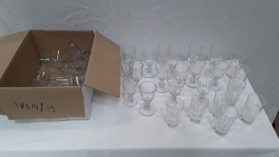une boîte de verres vides posée sur une table, avec une autre boîte de verres vides posée sur la table