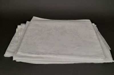 four white napkins on a table with a black background