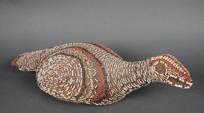un gros plan sur une sculpture représentant un oiseau posée sur une surface noire