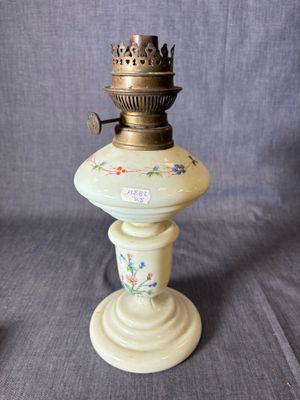 une lampe à huile à l'ancienne surmontée d'un oiseau