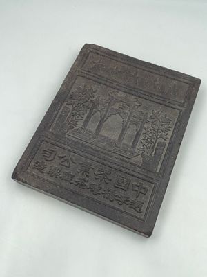 an old book sitting on top of a white table next to a white table