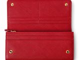 the red leather wallet is open and ready to be used as a purse