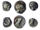 six ancient silver coins with different designs on them on a white surface