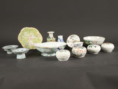 a group of chinese porcelain dishes and bowls on a black background