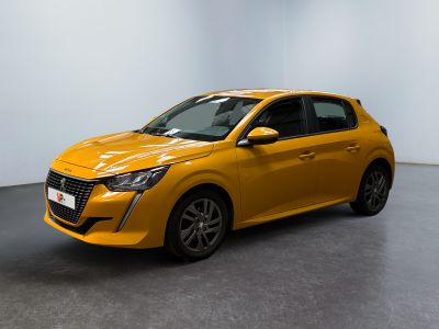Une voiture jaune est garée dans une pièce aux murs blancs.