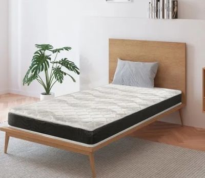 un lit sur lequel est posé un matelas dans une pièce