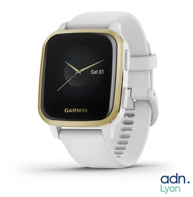 the garmin watch is white and gold with a black face