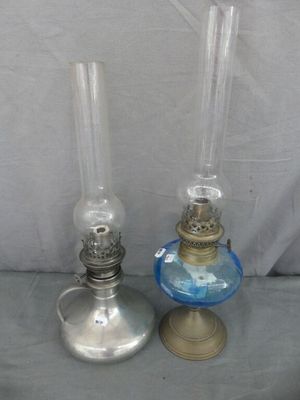 une paire de lampes à huile anciennes, dotées d'abat-jours en verre bleu, posées sur une table