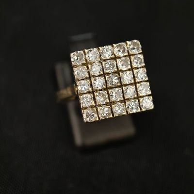un gros plan d'une bague sertie d'un diamant carré sur une surface noire