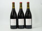 three bottles of red wine sitting next to each other on a white surface
