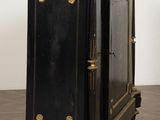 a black and gold cabinet on wheels on a wooden floor
