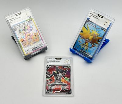 trois cartes à collectionner pokemon sont posées sur une table les unes à côté des autres