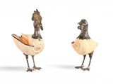 paire de figurines d'oiseaux en argent et en bronze sur fond blanc