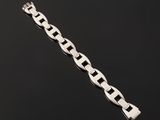 a close up of a silver bracelet on a black surface