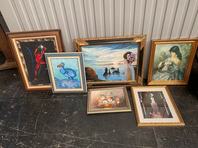 some of the paintings are sitting on the floor next to each other