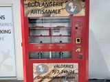a red vending machine sitting on the side of a building