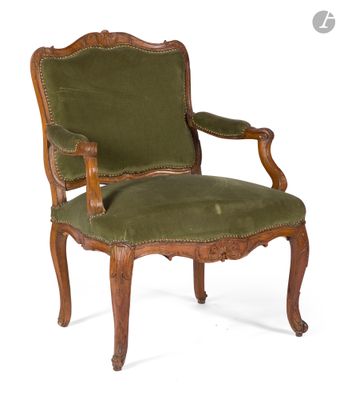 un fauteuil rembourré vert, avec une structure et des accoudoirs en bois