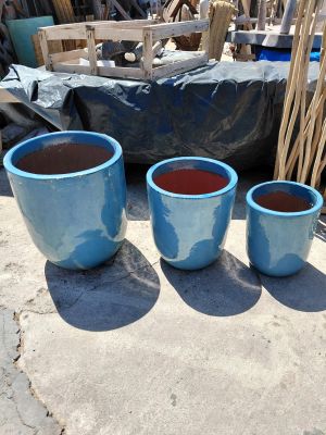 three blue pots sitting next to each other on the ground