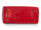 a close up of a red purse on a white surface