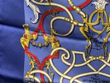 un gros plan sur une écharpe bleue ornée de motifs dorés et rouges