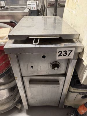 une machine qui se trouve dans une cuisine, à côté de quelques pots de ketchup