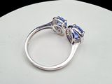 an image of a diamond and sapphire ring sitting on a white surface