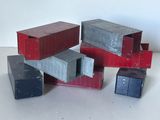 une pile de petits récipients rouges et gris posés sur une table