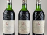 trois bouteilles de vin posées sur une table blanche
