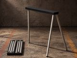 un tabouret noir posé par terre à côté de deux bâtons