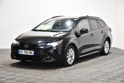 La Toyota Corolla est garée dans une pièce dont le sol est à carreaux.