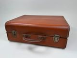 a brown leather suitcase sitting on a white surface
