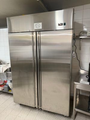 a stainless steel refrigerator in a kitchen with a microwave on the counter