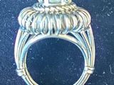 an image of a close up of a silver ring on a black surface