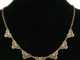 un collier en or autour du cou d'un mannequin, sur fond noir