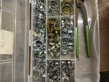 une boîte en plastique remplie d'une multitude de vis et d'écrous de toutes sortes