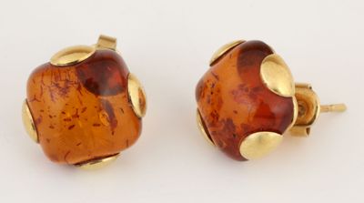 paire de boucles d'oreilles à clous en verre jaune et marron sur fond blanc