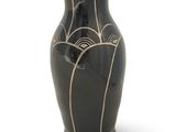 a black vase with a design on it on a white surface