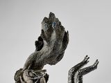 une image représentant une sculpture de deux mains sortant du sol